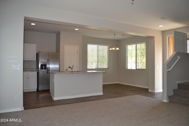 kitchen with sink, an island with sink, dark wood-type flooring, and stainless steel refrigerator with ice dispenser