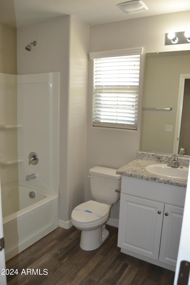 full bathroom with  shower combination, toilet, vanity, and hardwood / wood-style flooring