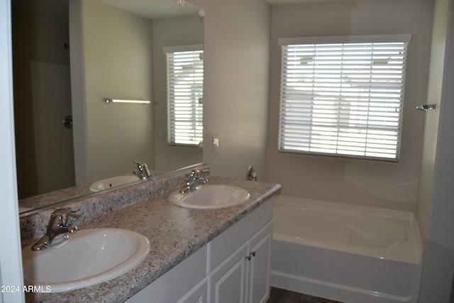 bathroom featuring double vanity and a bath