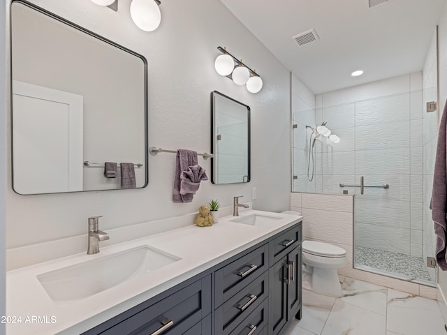 bathroom featuring vanity, a shower with shower door, and toilet