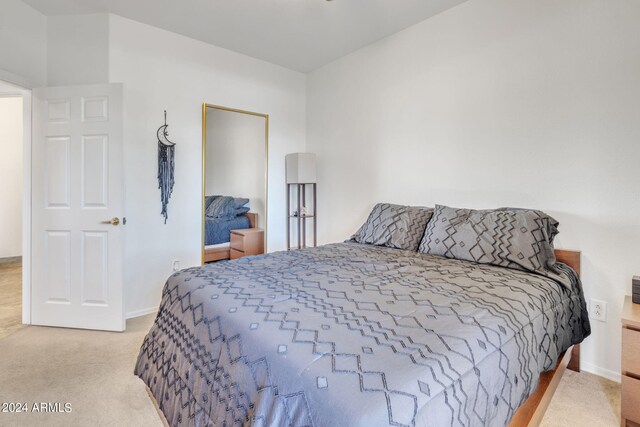 bedroom with light colored carpet and baseboards