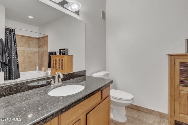 bathroom featuring vanity, visible vents, shower / bath combo with shower curtain, tile patterned floors, and toilet