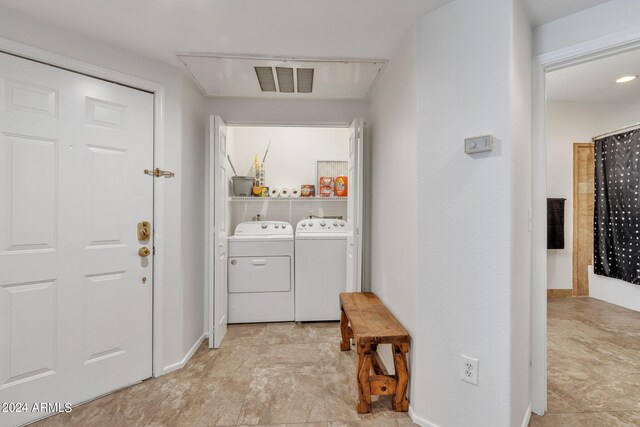 clothes washing area featuring visible vents, washer and dryer, and laundry area