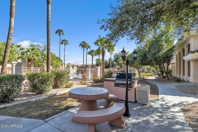 view of property's community with a patio, area for grilling, and fence