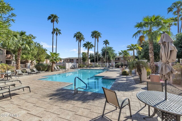 pool with a patio area and fence