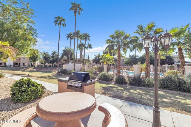 view of patio / terrace featuring area for grilling, a community pool, and fence