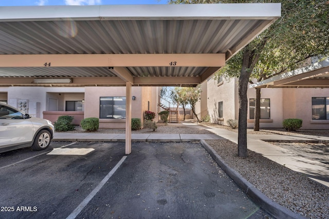 covered parking lot featuring stairs