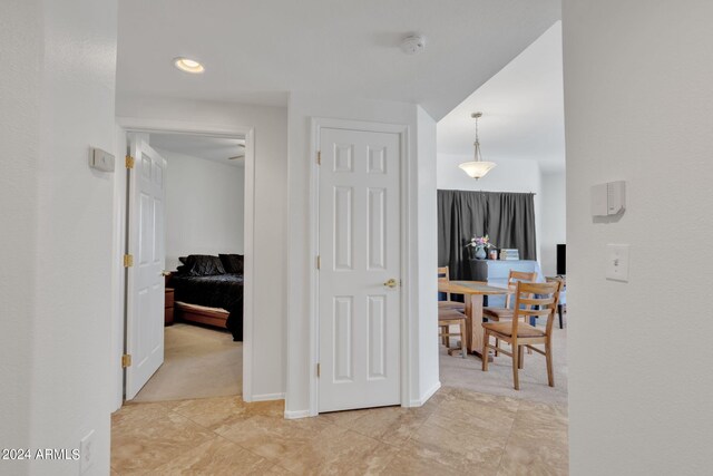 corridor with baseboards and light carpet