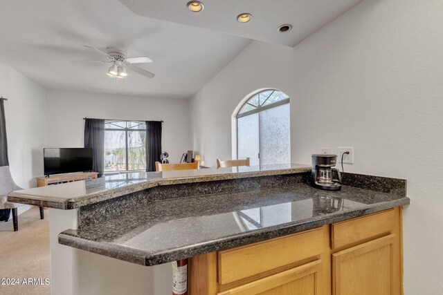 kitchen featuring ceiling fan, open floor plan, light colored carpet, dark stone counters, and recessed lighting