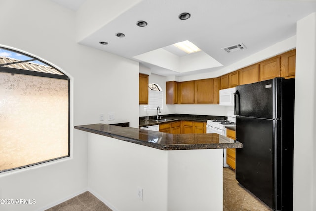 10030 W Indian School Rd Unit 218, Phoenix, AZ 85037 - kitchen with white appliances, a peninsula, and brown cabinetry