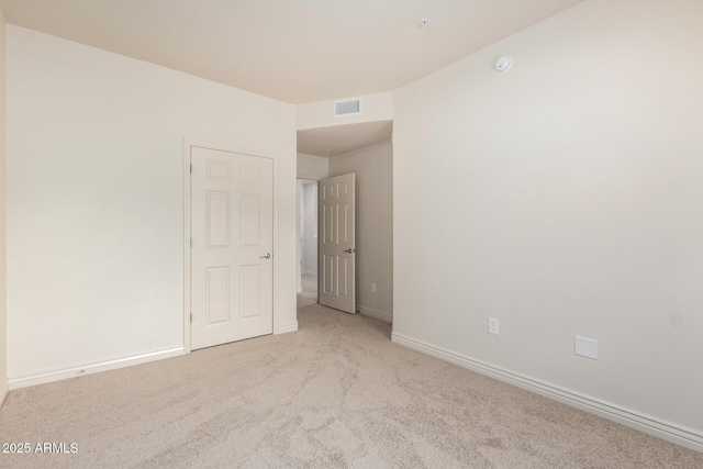 unfurnished room with carpet, baseboards, and a smoke detector