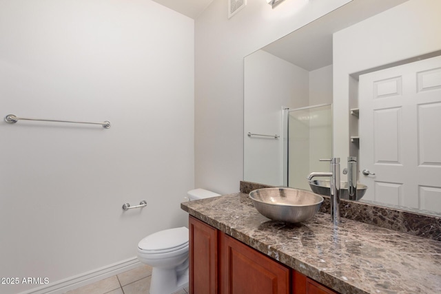 bathroom featuring tile patterned flooring, vanity, toilet, a shower with shower door, and baseboards