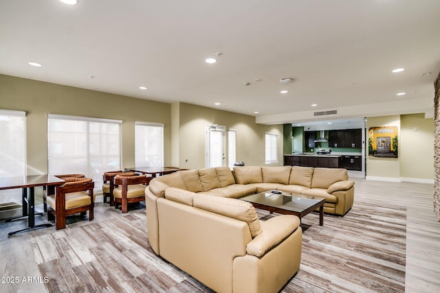 living room featuring light wood-style floors, recessed lighting, healthy amount of natural light, and baseboards