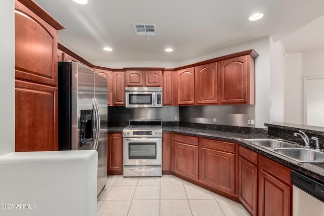 kitchen with appliances with stainless steel finishes, a sink, light tile patterned floors, and recessed lighting