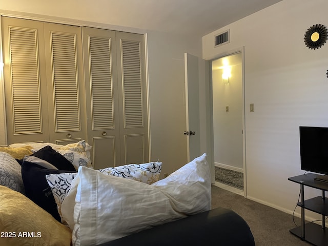 carpeted bedroom with a closet, baseboards, and visible vents