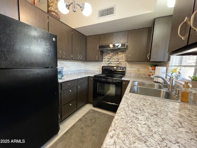 kitchen with backsplash, black appliances, under cabinet range hood, visible vents, and a sink