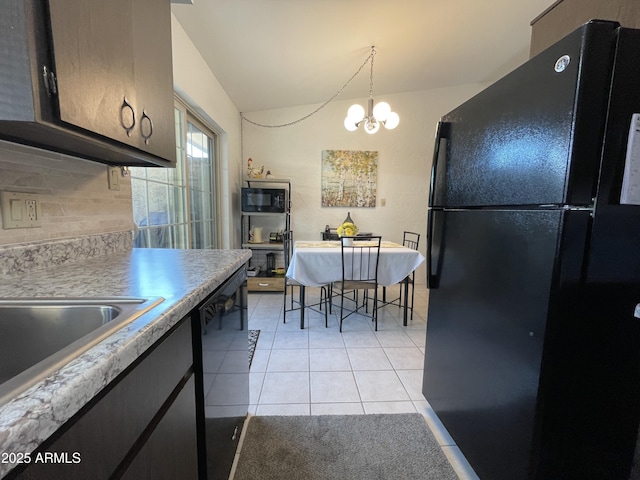 kitchen with black appliances, a chandelier, light tile patterned flooring, light countertops, and decorative backsplash