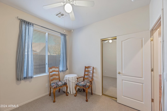 living area with ceiling fan and light colored carpet