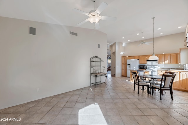 tiled dining room with high vaulted ceiling, ceiling fan, and sink