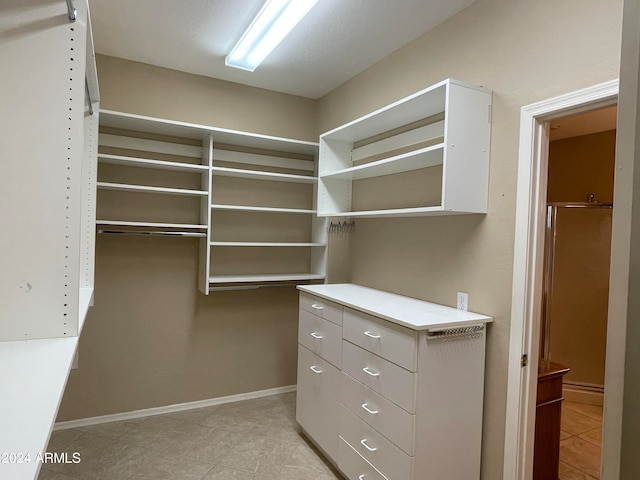 spacious closet with light tile patterned floors