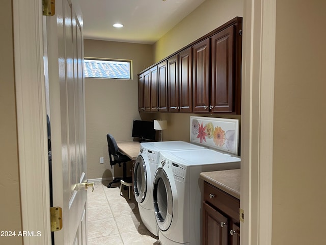 laundry room featuring cabinets, light tile patterned flooring, and washing machine and dryer