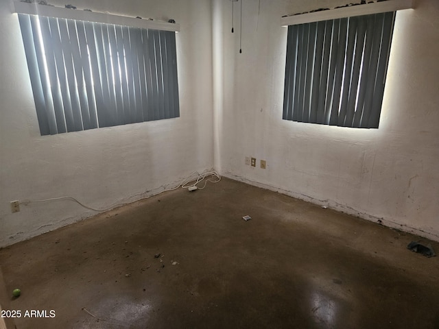 unfurnished room with concrete flooring