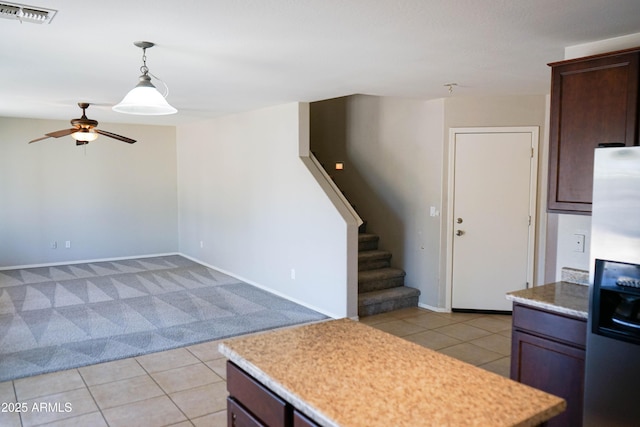 kitchen with stainless steel refrigerator with ice dispenser, dark brown cabinetry, light tile patterned floors, and pendant lighting