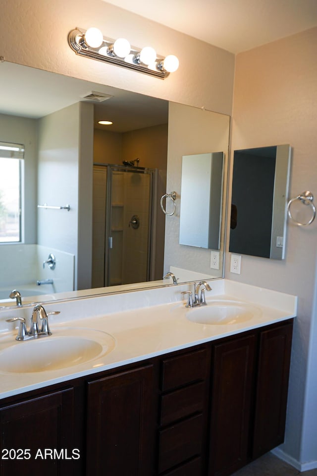 bathroom with vanity and shower with separate bathtub