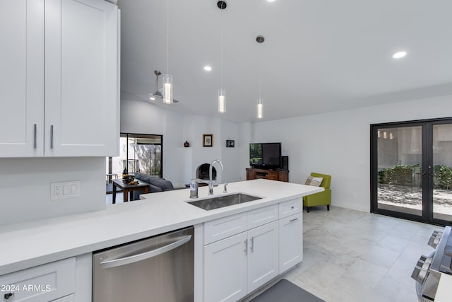 kitchen with decorative light fixtures, white cabinets, sink, and stainless steel dishwasher