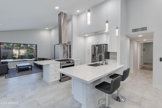 kitchen featuring white cabinets, appliances with stainless steel finishes, hanging light fixtures, and kitchen peninsula