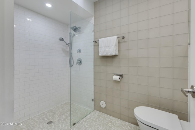 bathroom featuring toilet and a tile shower