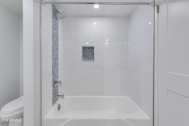 bathroom with toilet and tiled shower / bath combo