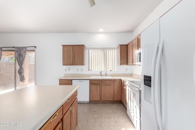 kitchen with sink, white appliances, and light tile patterned floors