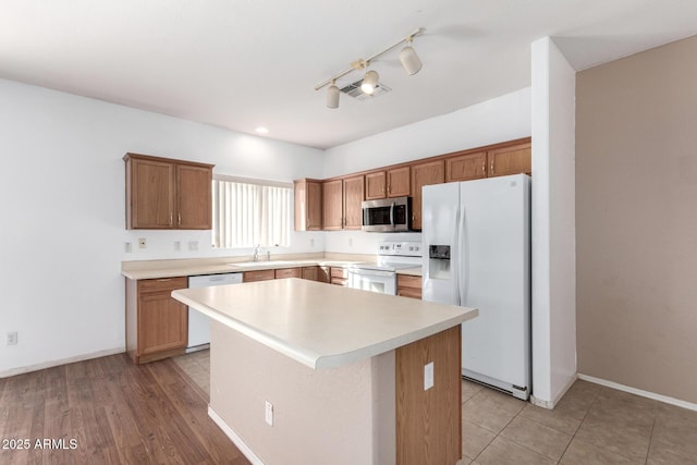 kitchen with sink, a kitchen island, and white appliances