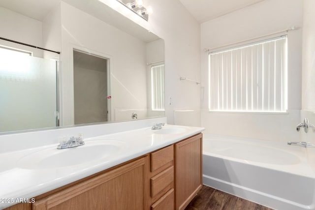 bathroom with hardwood / wood-style floors, vanity, and a bathtub