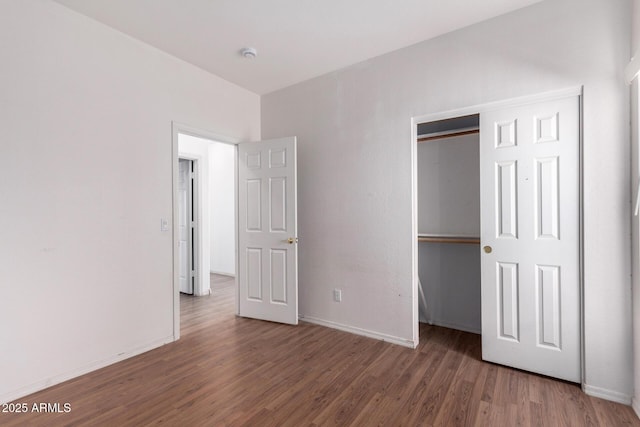 unfurnished bedroom featuring dark hardwood / wood-style floors and a closet