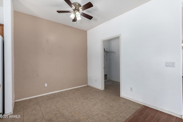 unfurnished bedroom with a closet, ceiling fan, and a spacious closet