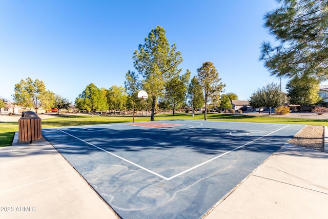 view of sport court with a lawn and basketball hoop