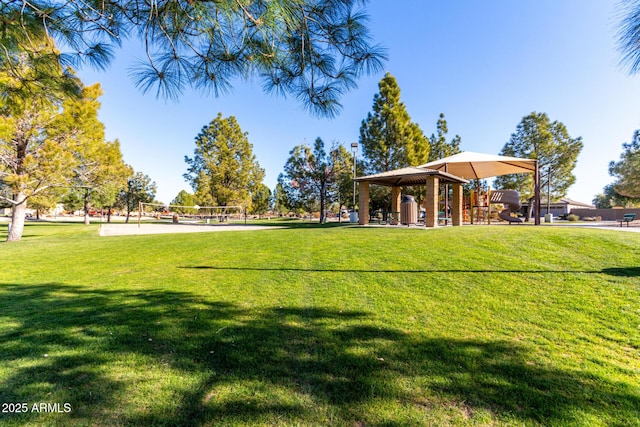 view of property's community with volleyball court, a gazebo, and a lawn