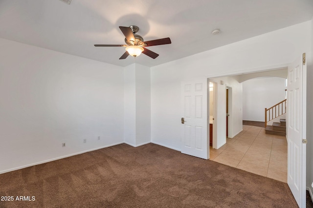3900 S Velero St, Chandler, AZ 85249 - spare room with light colored carpet, arched walkways, a ceiling fan, baseboards, and stairway