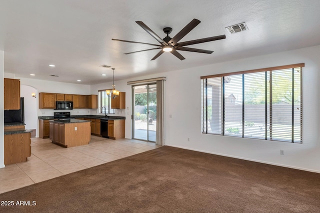 3900 S Velero St, Chandler, AZ 85249 - kitchen with dark countertops, a center island, brown cabinets, ceiling fan with notable chandelier, and black appliances