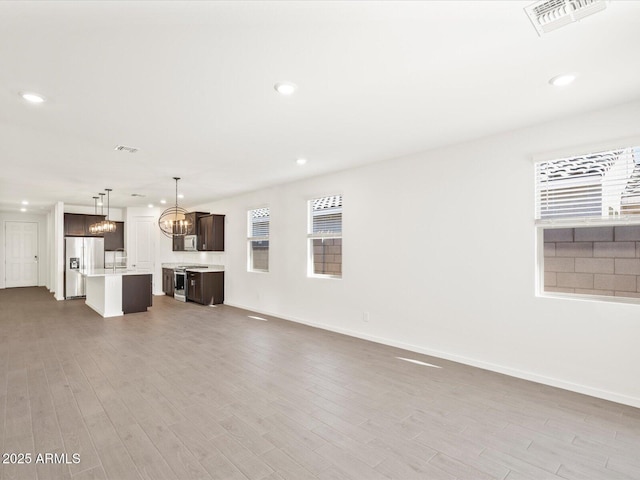 5537 S 246th Ave, Buckeye, AZ 85326 - unfurnished living room with a chandelier, wood finished floors, and recessed lighting