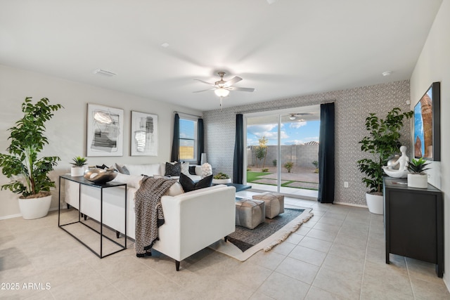 living area with ceiling fan, light tile patterned floors, visible vents, and wallpapered walls