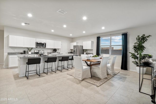 dining area featuring baseboards, visible vents, and recessed lighting
