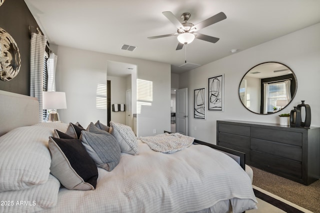 carpeted bedroom featuring a ceiling fan and visible vents