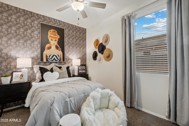 bedroom featuring wallpapered walls, baseboards, a ceiling fan, an accent wall, and carpet flooring