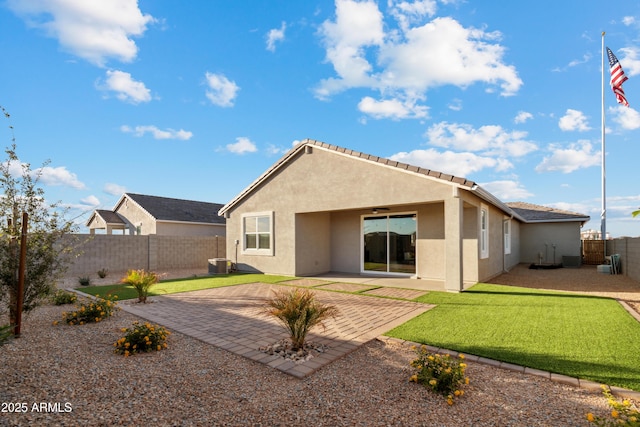 rear view of property featuring a fenced backyard, central AC, a lawn, stucco siding, and a patio area