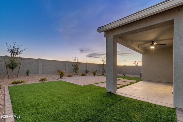 view of yard featuring a patio area, ceiling fan, and a fenced backyard