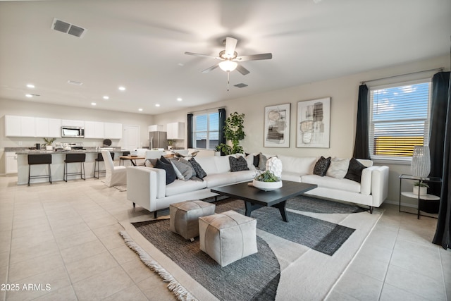 living room with recessed lighting, a healthy amount of sunlight, visible vents, and light tile patterned floors