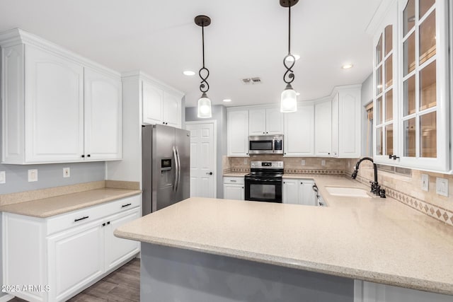 3444 E Flamingo Ct, Gilbert, AZ 85297 - kitchen with stainless steel appliances, glass insert cabinets, recessed lighting, a peninsula, and backsplash